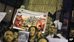 Protesters make a small demonstration of about 100 opposition activists, two holding a banner showing a photo of Egyptian President Hosni Mubarak, right, and his son Gamal Mubarak, left, in downtown Cairo, Egypt, 29 Nov 2010