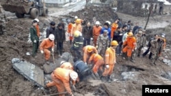 Rescuers search for victims after a landslide hit Zhenxiong county, Yunnan province, China, January 11, 2013.