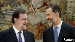 FILE - Spain's Prime Minister Mariano Rajoy (L) talks to King Felipe after taking his oath during a ceremony at Zarzuela Palace in Madrid, Spain, Oct. 31, 2016.