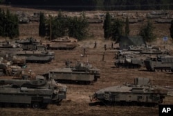 Israeli soldiers work on tanks and armoured personnel carriers (APC) in northern Israel, Sept. 30, 2024.