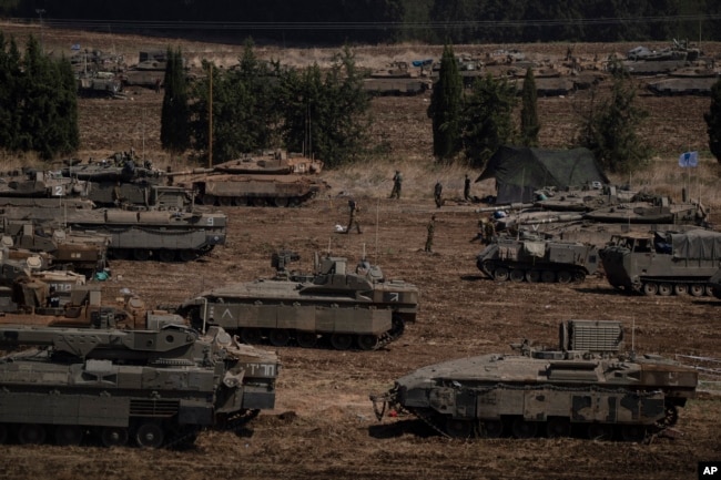 Israeli soldiers work on tanks and armoured personnel carriers (APC) in northern Israel, Sept. 30, 2024.