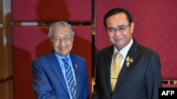 馬來西亞總理馬哈蒂爾（左）和泰國總理巴育在2019年曼谷東盟峰會。法新社