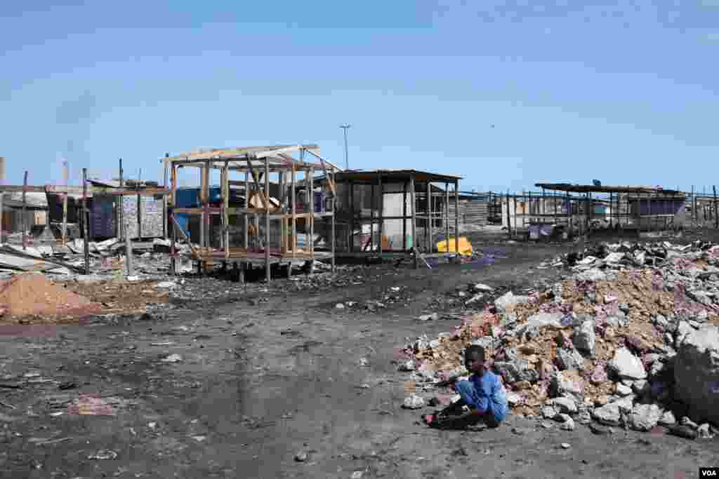 A child is playing near piles of refuse in the Agbogbloshie neighborhood of Accra, Ghana, Oct. 27, 2014. (Chris Stein/VOA) 