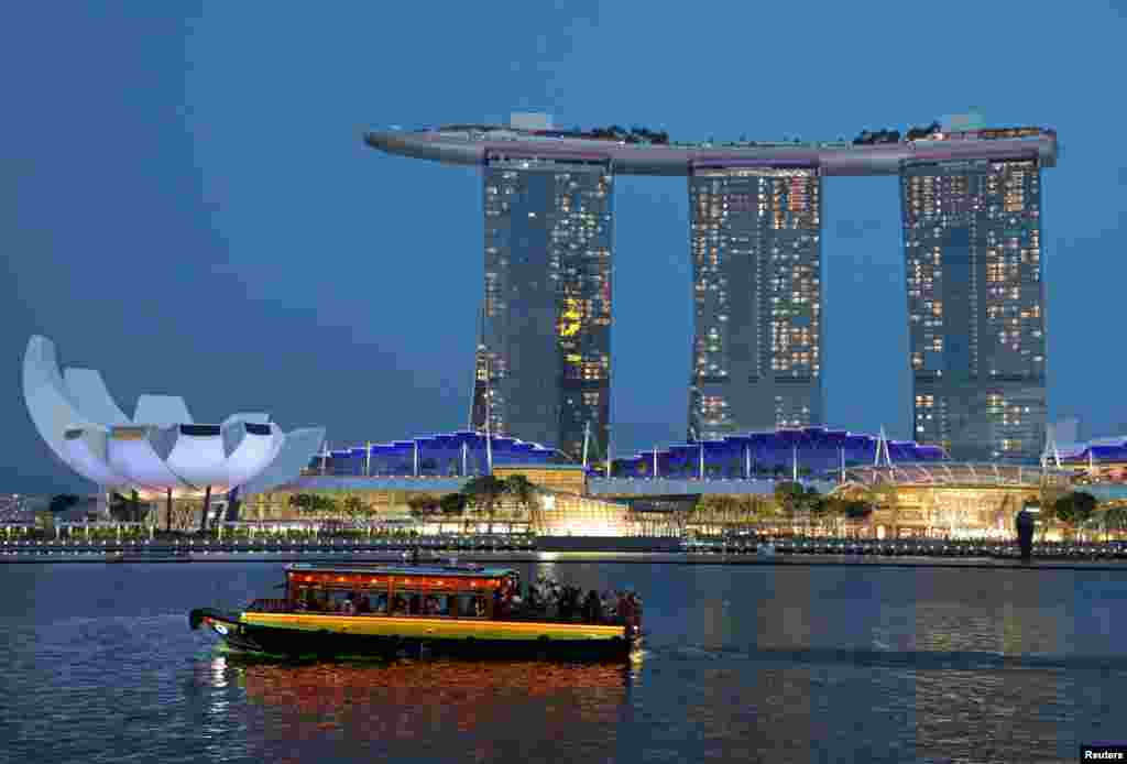 A tourist bum boat passes by the Marina Bay Sands hotel in Singapore, July 3, 2019.