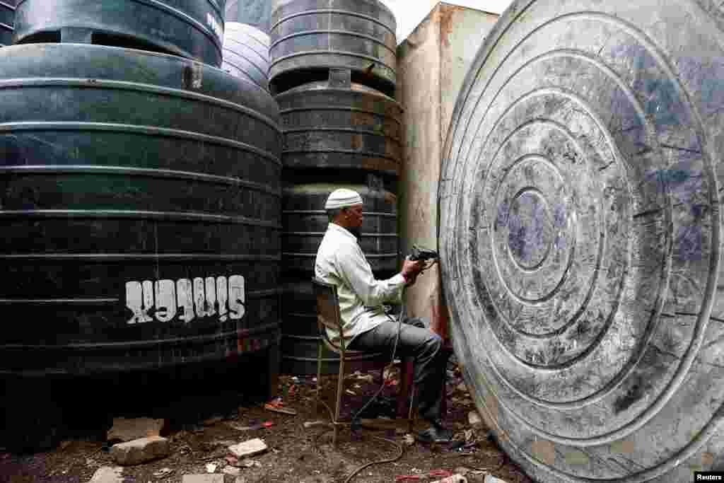A man repairs a water tank in Mumbai, India.