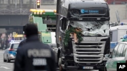 The damaged towing truck is towed away from the crime scene in Berlin, Germany, Tuesday, Dec. 20, 2016, the day after the truck ran into a crowded Christmas market.