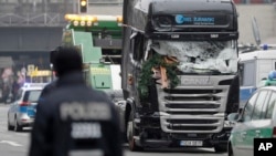 The damaged towing truck is towed away from the scene in Berlin, Germany, Dec. 20, 2016, the day after the truck ran into a crowded Christmas market, killing at least 12 people and injuring nearly 50 more.