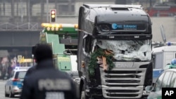 The damaged towing truck is towed away from the crime scene in Berlin, Germany, Tuesday, Dec. 20, 2016, the day after the truck ran into a crowded Christmas market.