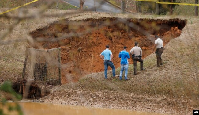 Lafayette County authorities oversee a break in the Audubon Dam in the North Point subdivision in Oxford, Miss., Feb. 23, 2019.