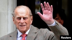 FILE - Britain's Prince Philip waves to members of the media as he leaves the King Edward VII Hospital in London, June 9, 2012.