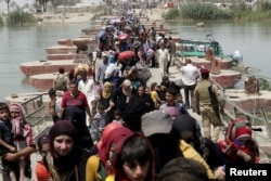 Displaced Sunni people fleeing Ramadi cross a bridge outside Baghdad, May 24, 2015. Iraqi forces recaptured territory from advancing Islamic State militants near the recently fallen city of Ramadi on Sunday.