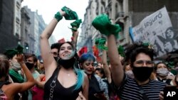 Aktivis hak-hak aborsi merayakan saat majelis rendah Argentina menyetujui RUU yang akan melegalkan aborsi di luar Kongres di Buenos Aires, Argentina, Jumat, 11 Desember 2020. (Foto: AP/Natacha Pisarenko)