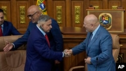 ARCHIVO - Karim Khan, fiscal de la Corte Penal Internacional (der), estrecha la mano del fiscal general venezolano Tarek William Saab después de una reunión en la Asamblea Nacional en Caracas, Venezuela, el 22 de abril de 2024. 