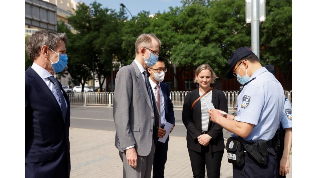 Seorang polisi memeriksa KTP Duta Besar Australia untuk China, Graham Fletcher, di luar Pengadilan Rakyat Menengah No. 2 Beijing, di Beijing, China, di mana penulis Australia Yang Hengjun diadili, 27 Mei 2021.