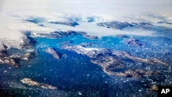 FILE - Icebergs float in a fjord after calving from glaciers on the Greenland ice sheet in southeastern Greenland. In an interview with Piers Morgan airing Jan. 28, 2018, on Britain's ITV News, the President Donald Trump said the world was cooling and warming at the same time and that claims of melting ice caps haven't come true.