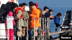 Migrants disembark from a Turkish coastguard boat after a failed attempt at crossing to the Greek island of Lesbos, in the Turkish coastal town of Dikili, Turkey, April 6, 2016.