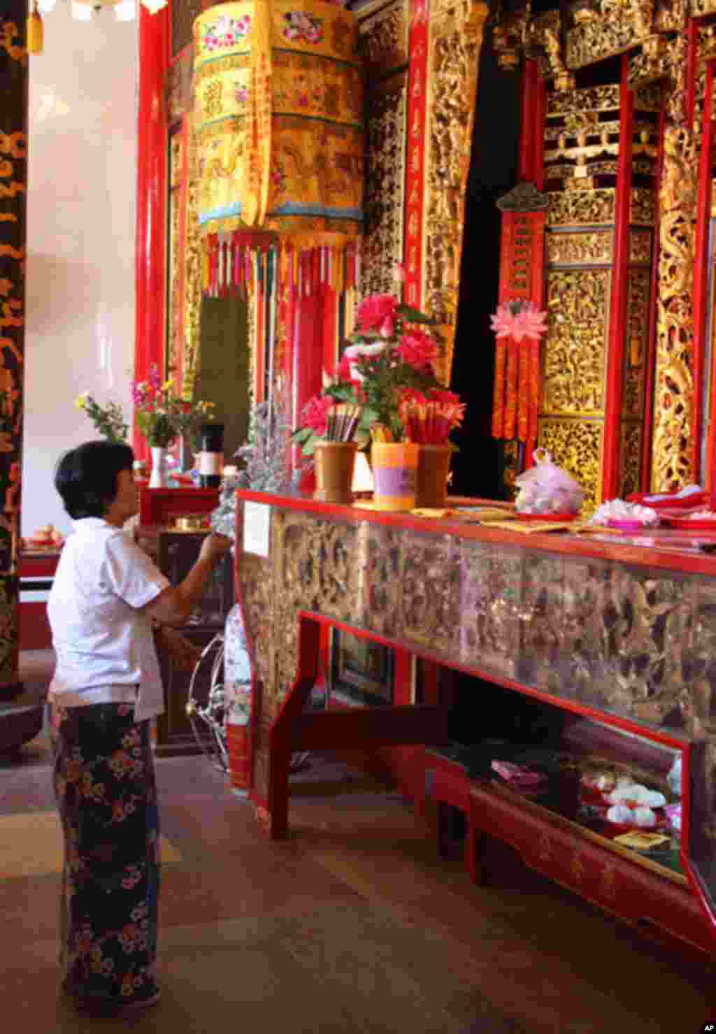 A woman worships at the Chinese temple in Rangoon. (VOA-D. Schearf)