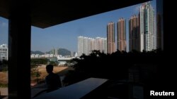 A man descends on an escalator near private housing estates in Hong Kong, Oct. 31, 2013. Many home buyers have shrugged off recent forecasts of a drop of up to 50 percent in prices over the next 12 months and decided to take a bet. 