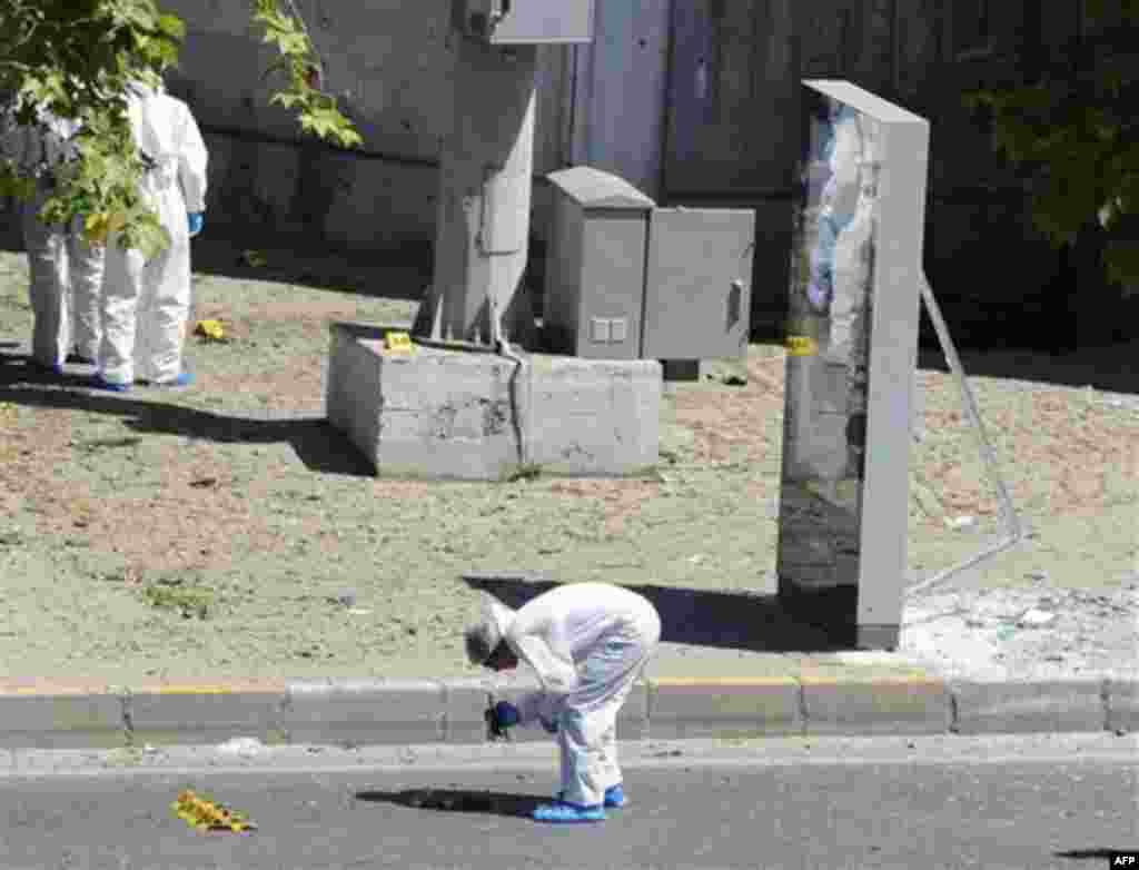 Forensic experts work at the scene after a bomb exploded at a bus stop during rush hour in Istanbul, Turkey, Thursday, May 26, 2011. A bomb placed on a bicycle near a bus stop exploded during morning rush hour in Istanbul on Thursday, injuring seven peop