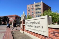 Orang-orang berjalan di University of Southern California di Los Angeles, 12 Maret 2019. (Foto: AP)