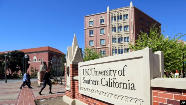 In this March 12, 2019 file photo, people walk at the University Village area of the University of Southern California in Los Angeles. 