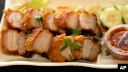 FILE - Crispy Pork Belly is presented at 