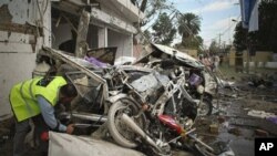 A Pakistani rescue worker examines a wreckage after a bomb blast in Faisalabad, Pakistan on Tuesday, March 8, 2011.