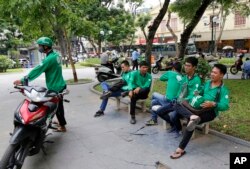 GrabBike drivers take a break at a small park in Hanoi, Vietnam, June 21, 2017. Vietnam’s motorbike taxis are seeing their business dry up as customers increasingly opt for ride hailing services like Uber and Grab-Taxi.