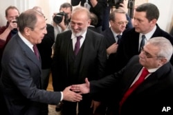 Russian Foreign Minister Sergey Lavrov, left, shakes hands with Syria's opposition members in Moscow, Russia, Jan. 27, 2017.