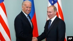 Le vice-président américain de l'époque, Joe Biden, à gauche, serre la main du Premier ministre russe de l'époque Vladimir Poutine à Moscou, en Russie, le 10 mars 2011. 