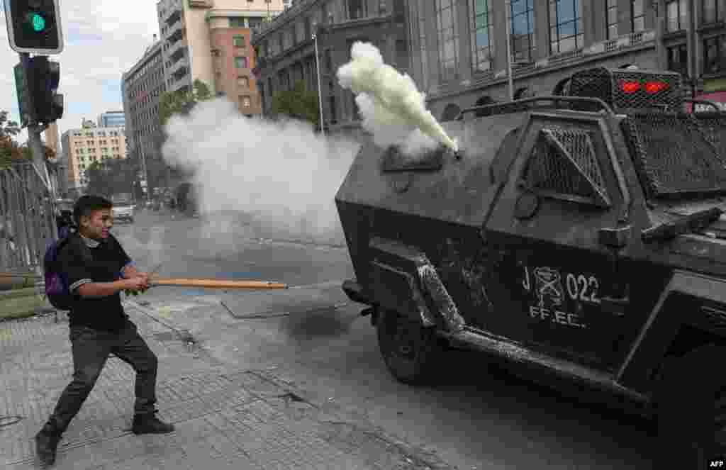 A student confronts riot police during a protest against Chile&#39;s President Sebastian Pinera government, in Santiago.