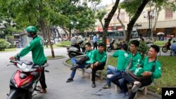 Pengemudi GrabBike beristirahat di sebuah taman di Hanoi, Vietnam, 21Juni 2017. 