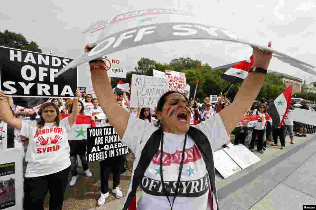 Syrian-American demonstrator Manar Kodamah leads a chant against possible U.S. military intervention in the conflict in Syria as a group of Syrian-Americans protest in front of the White House in Washington. 