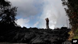 Hannique Ruder, 65, warga Leilani Estates, berdiri di atas lahar yang mengeras di dekat Pahoa, Hawaii, 11 Mei 2018. 