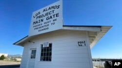 A sign marks a roadside rest stop that has been made to look like the historic security gate that all Manhattan Project workers passed through in Los Alamos, N.M., on June 26, 2023. (AP Photo/Susan Montoya Bryan)