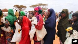 Women wait in line at a food distribution site in Dolo, Somalia, July 18, 2012.