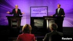 Australian Prime Minister and leader of the Australian Labor Party Kevin Rudd (L) speaks as the leader of the conservative opposition Tony Abbott listens on during their debate at the National Press Club in Canberra, August 11, 2013.