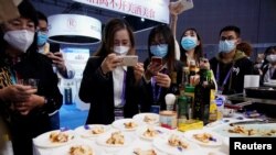 在上海参观中国国际进口博览会上的观展者给澳大利亚龙虾拍照。（2020年11月6日）