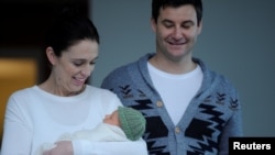 New Zealand Prime Minister Jacinda Ardern carries her newborn baby Neve Te Aroha Ardern Gayford with partner Clarke Gayford as she walks out of the Auckland Hospital in New Zealand, June 24, 2018.