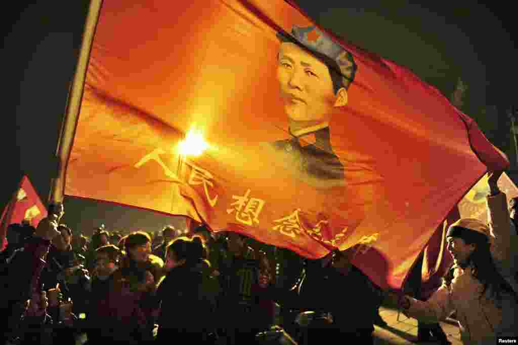 Supporters wave a flag with an image of Mao Zedong that says &quot;People missing Chairman Mao&quot;, as people gather to celebrate the 120th birth anniversary of the former leader in his hometown, Shaoshan, Dec. 25, 2013.