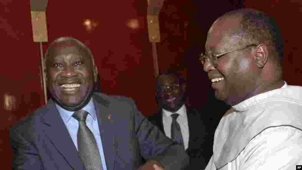Le président de la Côte d&#39;Ivoire Laurent Gbagbo, à gauche, sourit lors d&#39;une rencontre avec Mgr Jean Pierre Koutouan, à droite, venu le féliciter dans la ville d&#39;Abidjan, Côte d&#39;Ivoire, 10 décembre 2010.