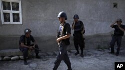 Kyrgyz soldiers rest after conducting house-to-house searches in a district inhabited by ethnic Uzbek Kyrgyz citizens in the southern Kyrgyz city of Osh, June 22, 2010.