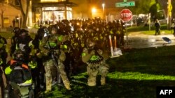 Les troupes de l'État du Minnesota se préparent à tirer des gaz lacrymogènes sur les manifestants devant le poste de police de Brooklyn Center, le 12 avril 2021.