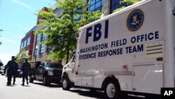 Kendaraan Tim Respon FBI diparkir di depan gedung Navy Yard, Washington DC untuk mengumpulkan bukti-bukti menyusul insiden penembakan di sekitar lokasi tersebut 18 September 2013 (Foto: dok).