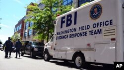 FILE - An FBI evidence response team vehicle is parked outside Building 197 at the Navy Yard in Washington as evidence of a mass shooting is collected, Sept. 18, 2013.