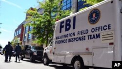 美国联邦调查局的“证据反应组”的汽车停在华盛顿海军大院一座建筑外面，搜集一次开枪滥杀案件的证据（2013年9月18日）