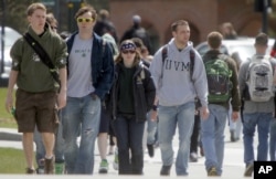 FILE - Students walk across campus at the University of Vermont in Burlington, Vermont.