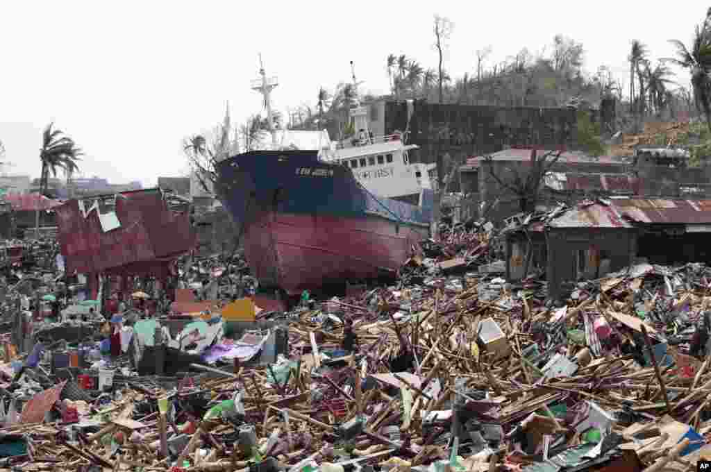 A ship lies on top of damaged homes after it was washed ashore by Typhoon Haiyan in Tacloban city, Leyte province, central Philippines. The city remains littered with debris from damaged homes as many complain of shortages of food and water and no electricity since Typhoon Haiyan slammed into their province.