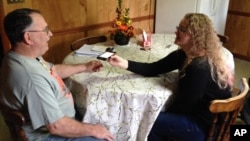 FILE - In this Nov. 27, 2015, file photo, Rhiannon Leonard interviews her boss, Gary Himes in Weverton, Md., for StoryCorps' Great Thanksgiving Listen oral history project. The Great Thanksgiving Listen will be held for a third year in 2017. The event calls for high school students to record a conversation with an elder over the holiday weekend using the StoryCorps app.