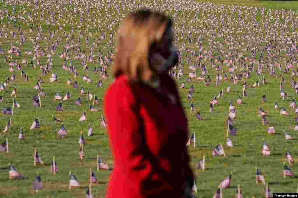 낸시 펠로시 미국 하원의장이 워싱턴 내셔널몰에 신종 코로나바이러스 희생자 20만명을 추모하기 위해 설치된 성조기 앞에서 묵념하고 있다. 